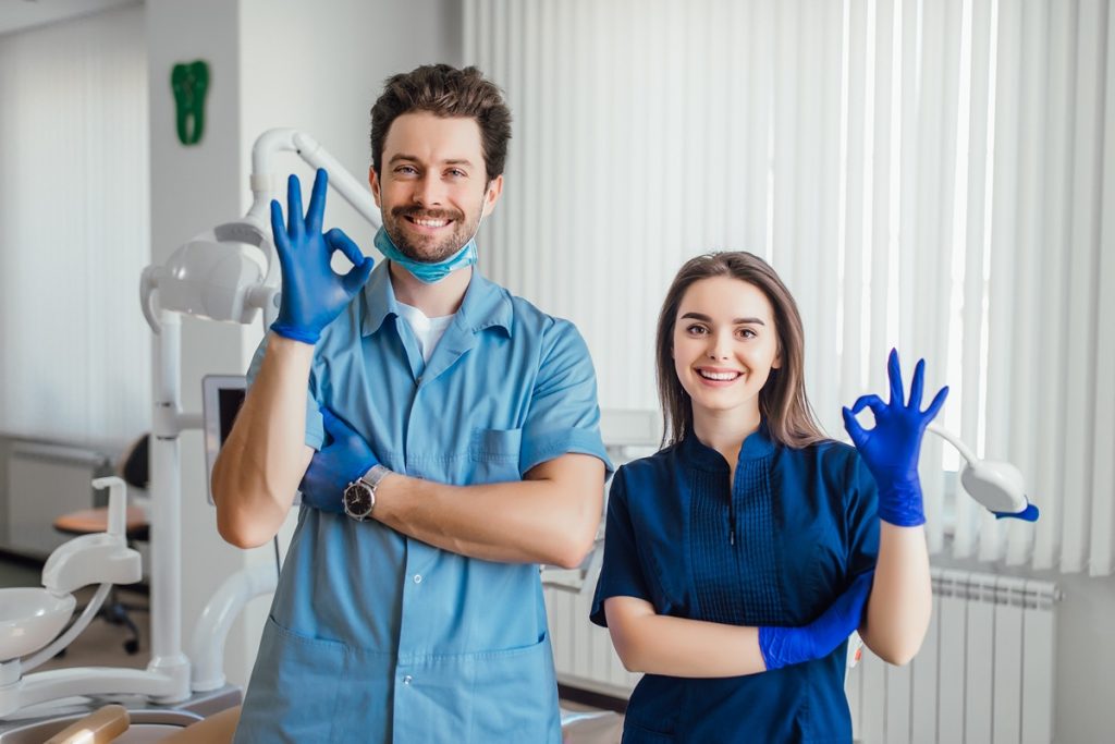 Dental hygienist and assistant smiling in Toronto clinic