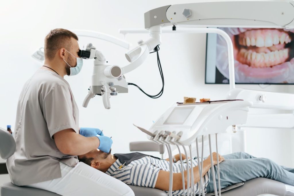 Dentist performing advanced oral cancer screening in Toronto with high-tech tools.