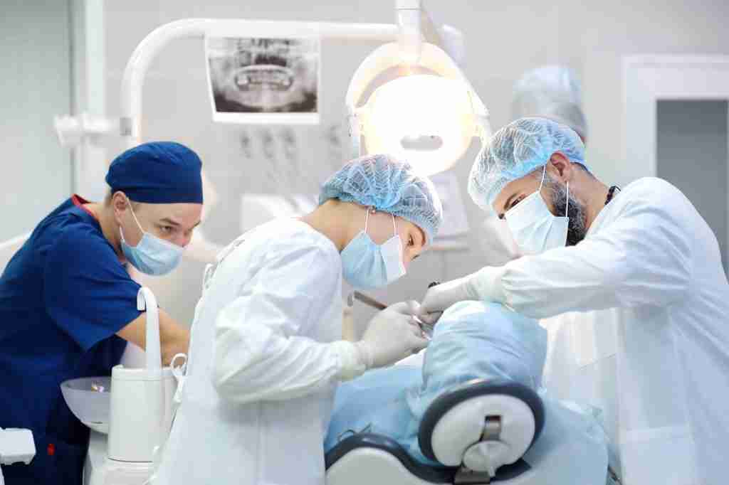 Oral surgeons in Toronto performing a sterile dental procedure with full surgical gear.